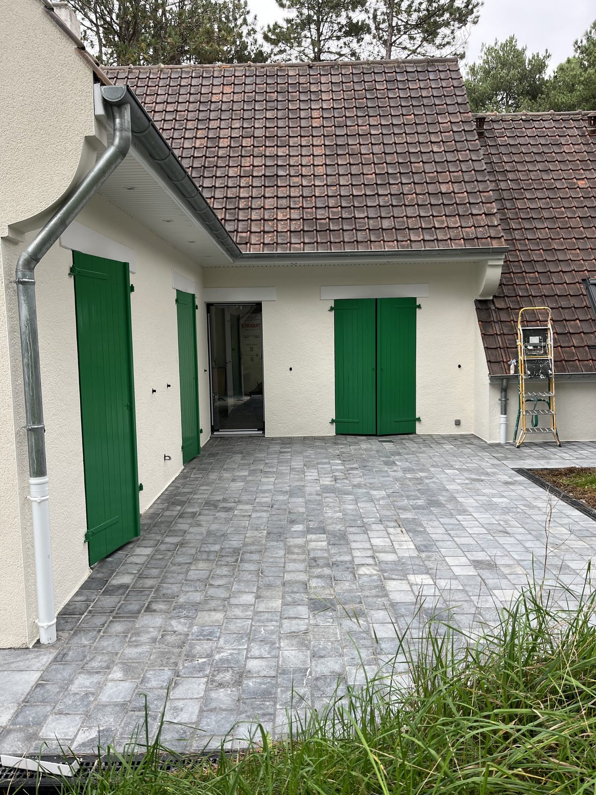 Maison aux volets repeints, façade extérieure entretenue